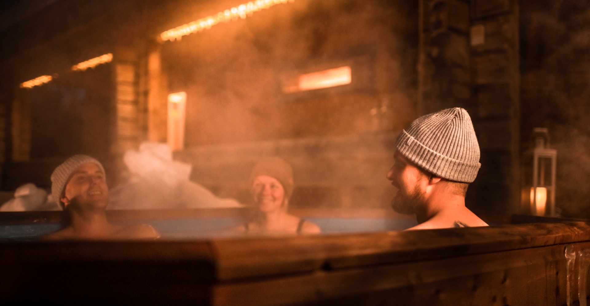 Three people covered by steam, enjoying their time in the hot tub.