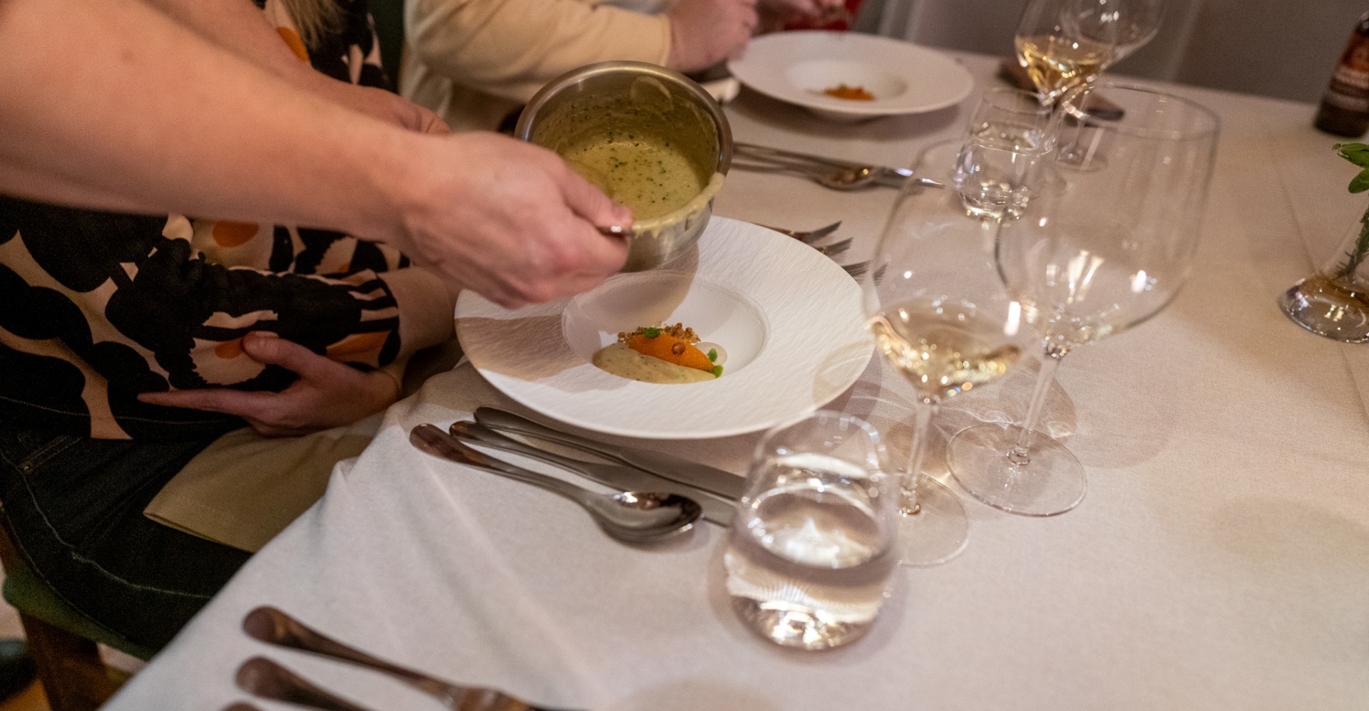 A hand pouring sauce on the gourmet dish served at the Aihki restaurant.