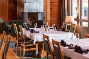 A kitchen with lined-up tables, dressed in white tablecloth.