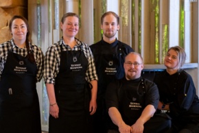 Restaurant staff looking into the camera and smiling.