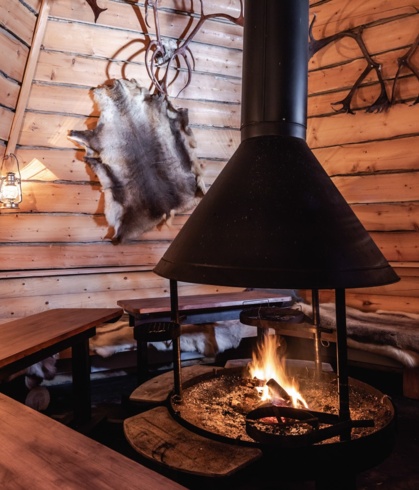 A fireplace in a wooden, round hut.