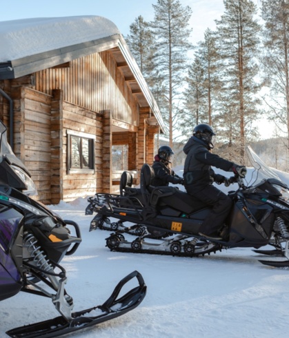 People on electric snowmobiles getting ready for a snow safari.
