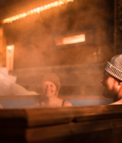 Three people covered by steam, enjoying their time in the hot tub.