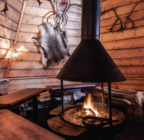A fireplace in a wooden, round hut.