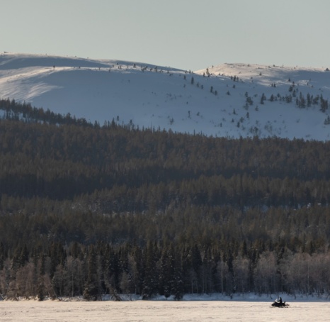 Two people in the distance eSleding into the wilderness.