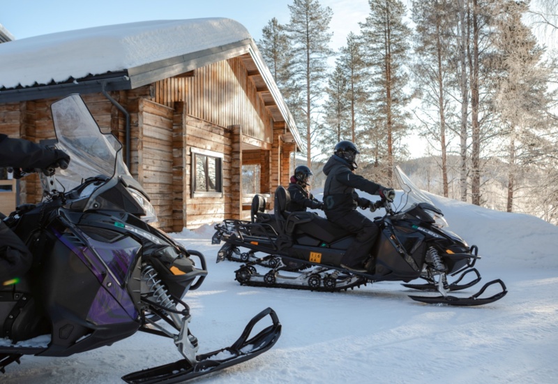 People on electric snowmobiles getting ready for a snow safari.
