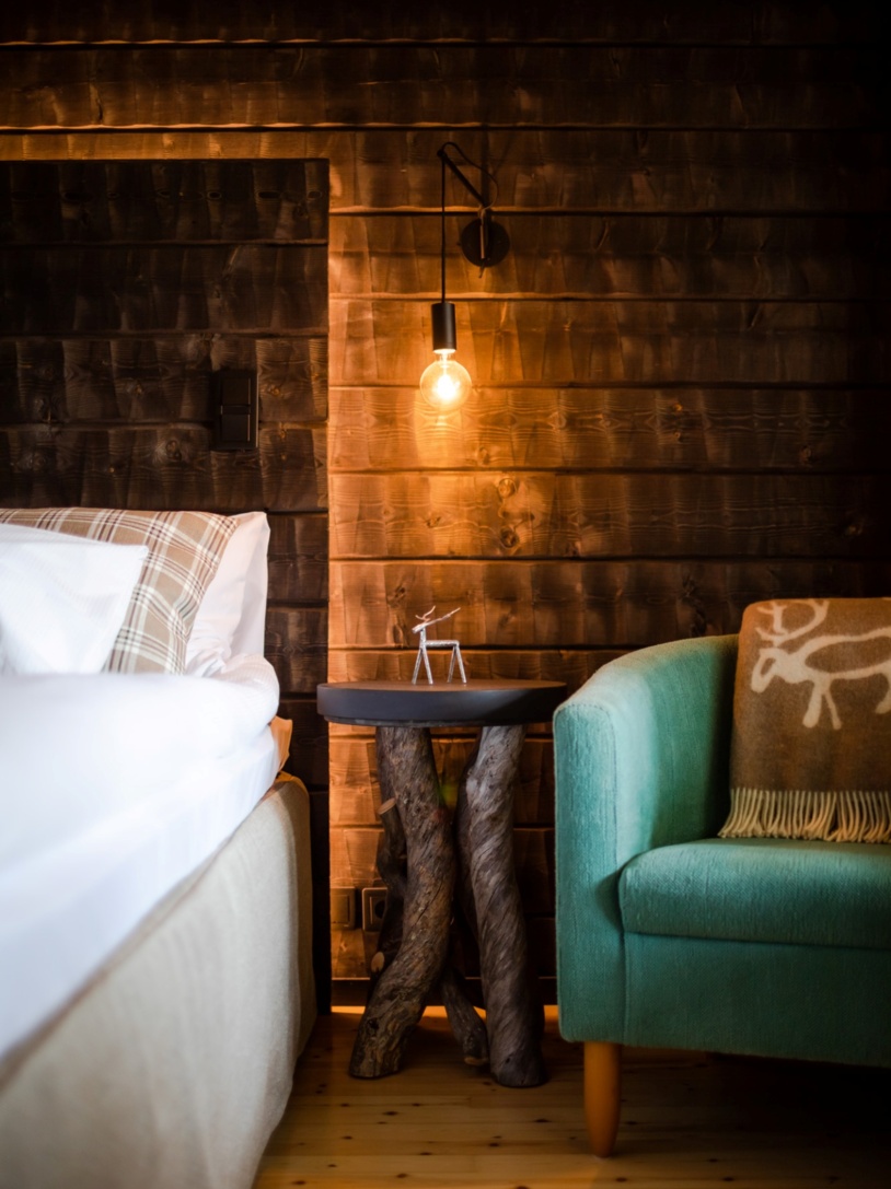 A timber bedroom illuminated by a single light bulb casting warm light on the furniture.