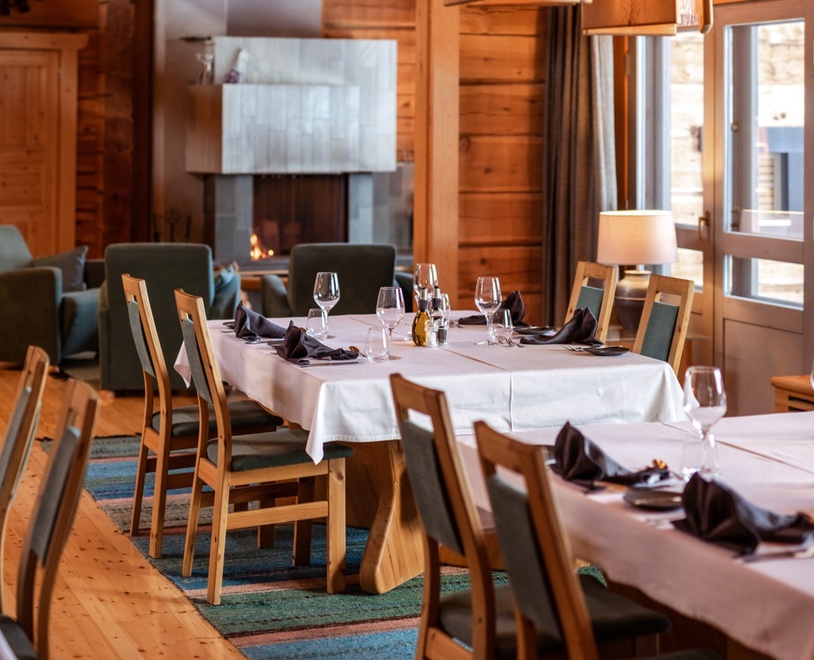A kitchen with lined-up tables, dressed in white tablecloth.