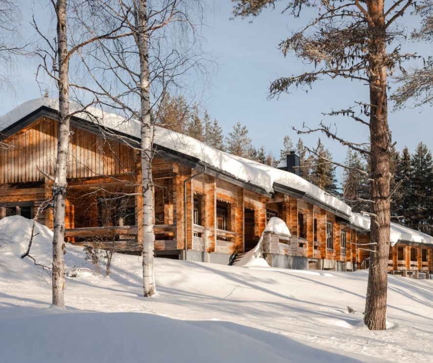 A wooden cottage coated in snow.