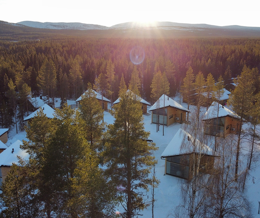 落雪屋顶与落地玻璃的木屋藏于松林，日出时分可远眺群山