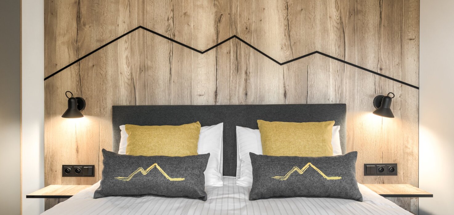 Sypialnia z pościelonym łóżkiem i pięknym widokiem na góry – idealne miejsce na nocleg w Zakopanem.