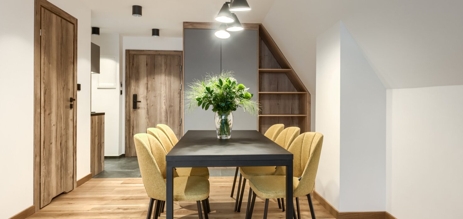 Duży stół dla sześciu osób w jasnym i przestronnym apartamencie – idealny dla grupy.