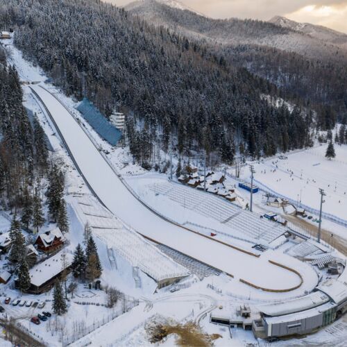 Skocznia narciarska Wielka Krokiew w Zakopanem, otoczona lasem, z widoczną infrastrukturą sportową.