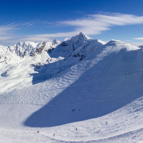 Zimowy krajobraz Tatr z ośnieżonymi szczytami i pokrytymi śniegiem drzewami.