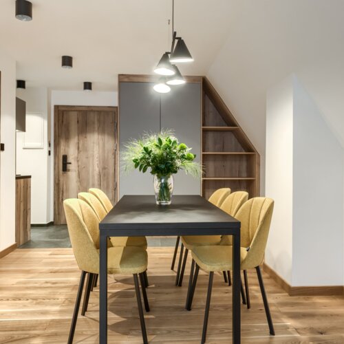 Duży stół dla sześciu osób w jasnym i przestronnym apartamencie – idealny dla grupy.