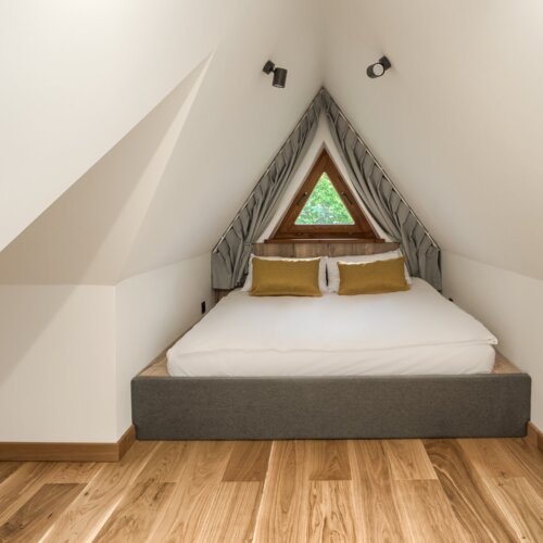 Starannie przygotowane łóżko z miękką pościelą w przytulnym apartamencie.