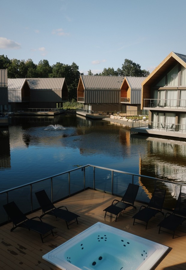 Nowoczesne domki nad jeziorem z prywatnymi balkonami, jacuzzi przy wodzie, leżakami i fontanną na stawie