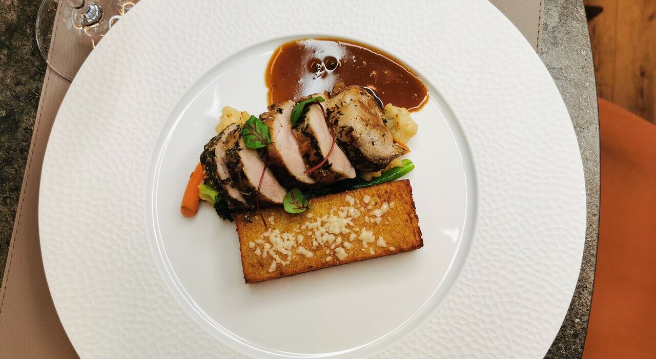 presented dish in an Italian restaurant in Krakow – meat, sides, and sauces in an authentic style.