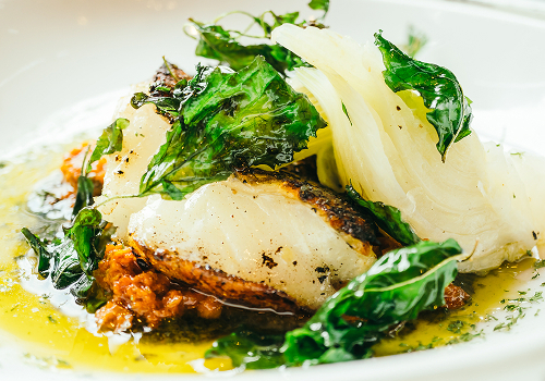 Gebratener weißer Fisch mit geschmortem Fenchel, knusprigem Blattgemüse, Tomatenragout und Zitronen-Buttersauce