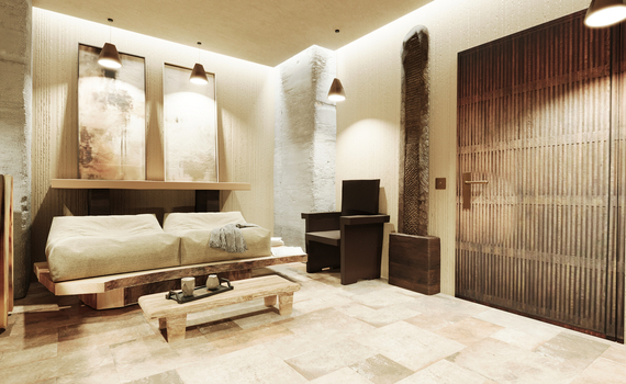 Strefa relaksu w stylu zen: niska drewniana leżanka z poduszkami i tacą do herbaty, lampy wiszące, fakturowane ściany i drewniane drzwi