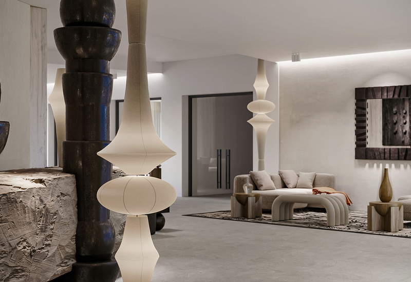 Nowoczesne lobby hotelowe z rzeźbiarskimi lampami, kamiennymi akcentami, zaokrągloną sofą i pufami na wzorzystym dywanie, miękkie oświetlenie