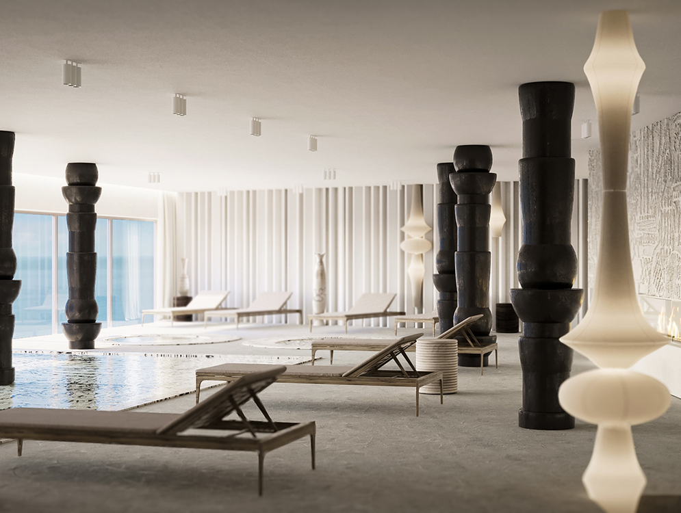 Strefa spa wewnątrz z płytkim basenem, leżakami, rzeźbiarskimi czarnymi filarami, panoramicznymi oknami z widokiem na morze i kominkiem