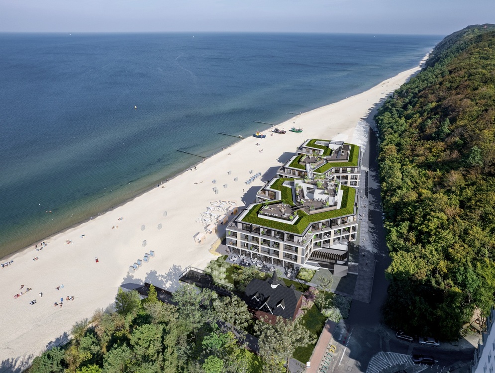 Modernes Strandhotel mit begrünten Dachterrassen, Rooftop-Lounges, Liegen am breiten Sandstrand, direktem Meerzugang und angrenzendem Küstenwald.