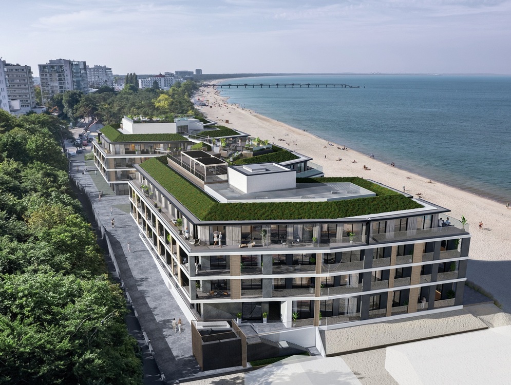 Modernes Strandhotel mit begrünten Dächern, Glasbalkonen und Meerblick-Terrassen über feinem Sandstrand und Seebrücke.
