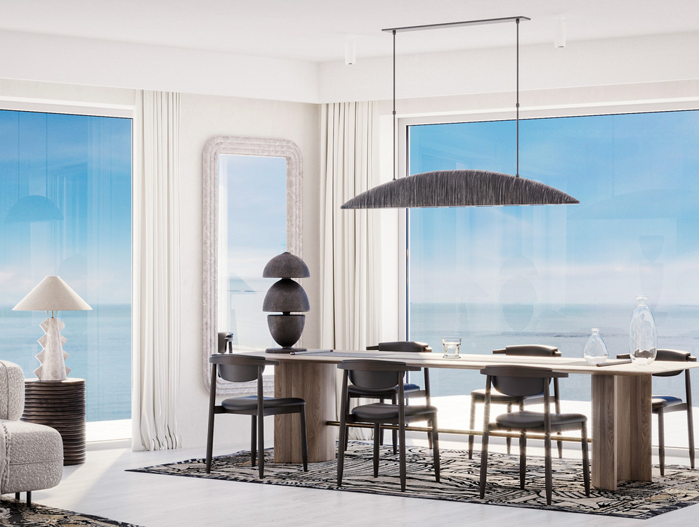 Jasna jadalnia w nadmorskim apartamencie z drewnianym stołem dla sześciu, wygodną sofą, rzeźbiarskimi lampami i panoramicznym widokiem na morze
