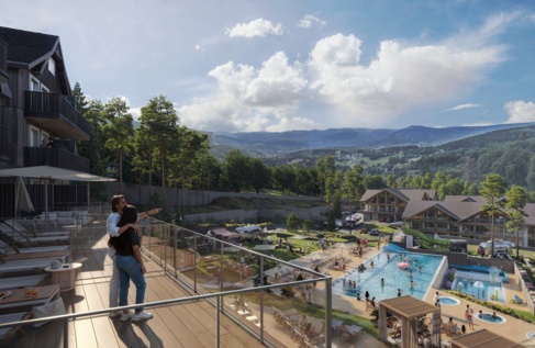 Para patrzy z tarasu na hotelowy aquapark, góry w tle