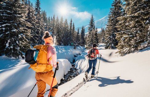 Dwie osoby idące na nartach przez śnieg