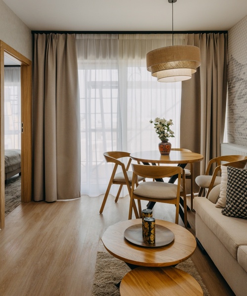 Pokój hotelowy z kanapą, stolikiem kawowym, stołem i krzesłami