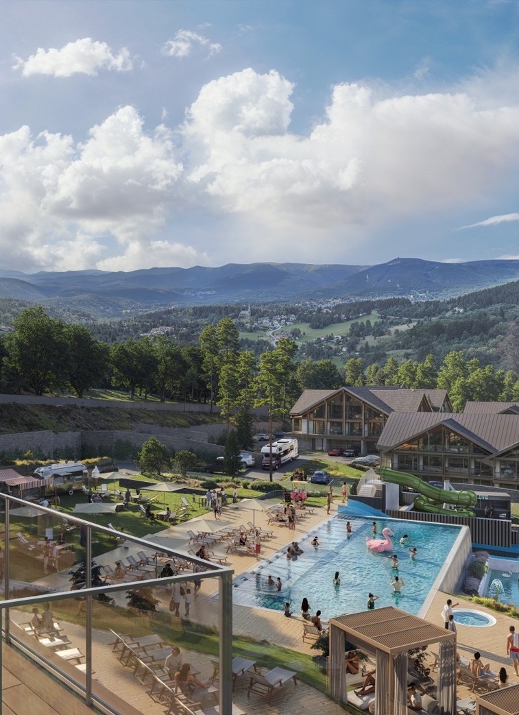 Para patrzy z tarasu na hotelowy aquapark, góry w tle