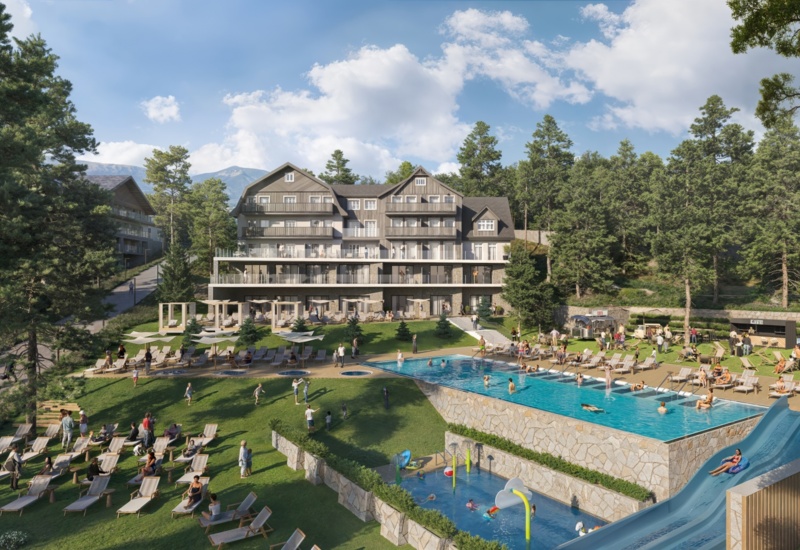 Widok na rozbudowany zewnętrzny aquapark z basenem i strefą dla dzieci przy hotelu, w tle góry
