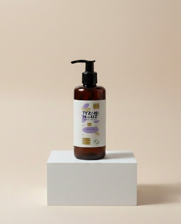Bursztynowa butelka z pompką z mydłem w płynie na białym postumencie — minimalistyczny akcent spa w łazience