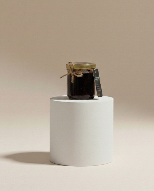 Mały słoik rzemieślniczego dżemu ze sznurkiem i etykietą na białym podium — idealny upominek powitalny lub dodatek do śniadania