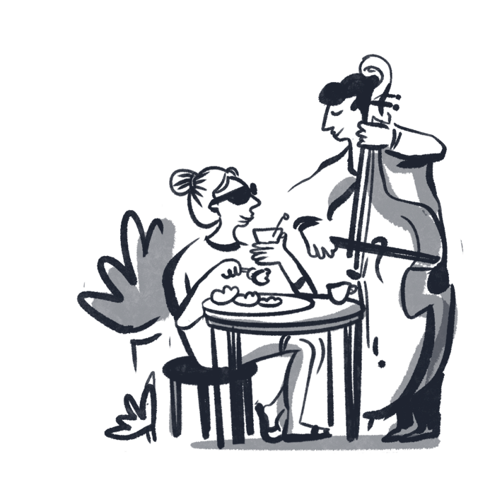 Gość relaksuje przy kawie przy stoliku, słuchając muzyka grającego na kontrabasie, tworząc kameralną atmosferę.