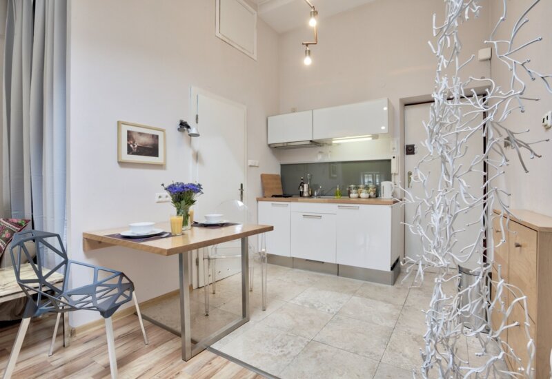 Modern, compact kitchen in-room with dining for two, light furniture and refined accessories.