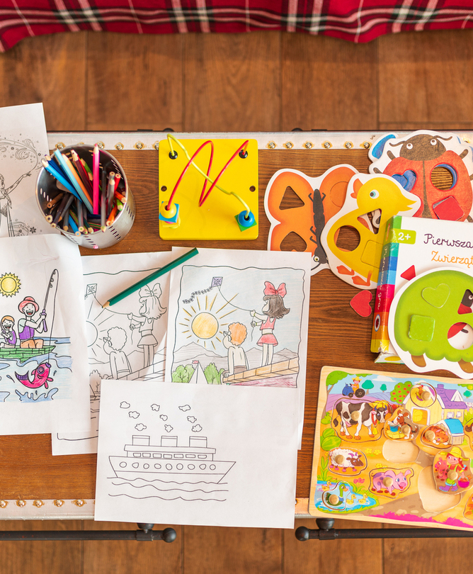 Kinderspieltisch mit Buntstiften, Ausmalbildern, Puzzles und Büchern — familienfreundlicher Spielbereich im Hotel