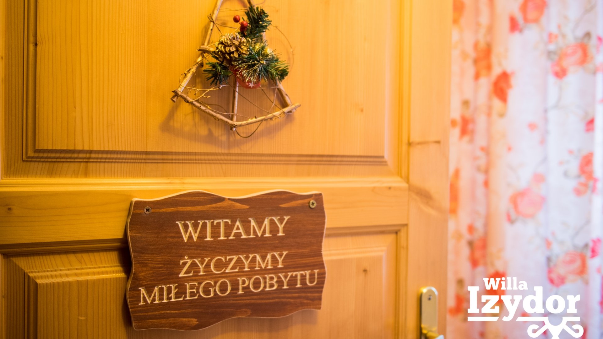 drzwi z napisem powitalnym w Willi Izydor