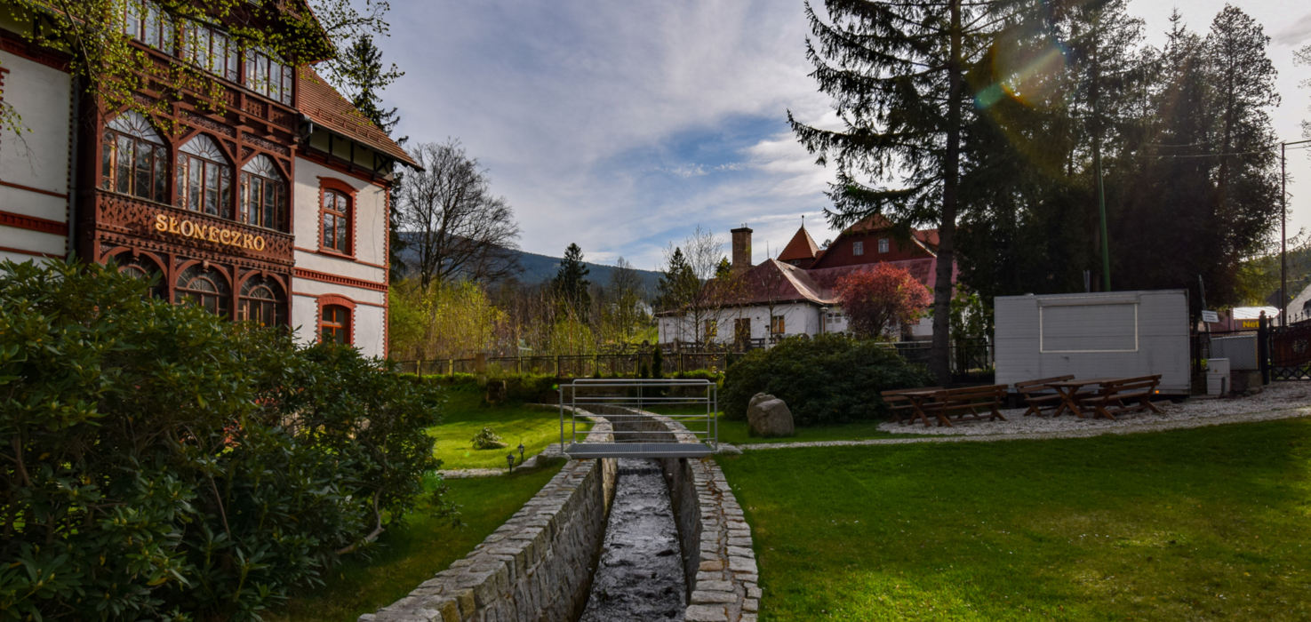 Vue pittoresque sur la pension Słoneczko avec jardin et montagnes en arrière-plan à Szklarska Poręba