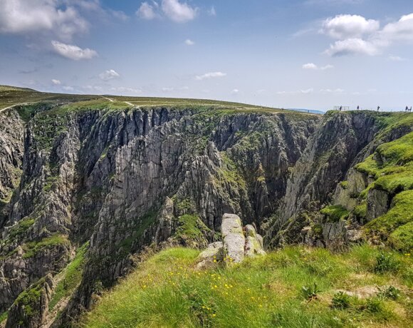 Escarpés cirques glaciaires de Śnieżne Kotły et prairies vertes dans un paysage de montagne sous un