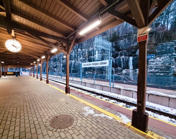 Quai de la gare de Szklarska Poręba Górna avec toit, offrant une vue sur les rochers de montagne en