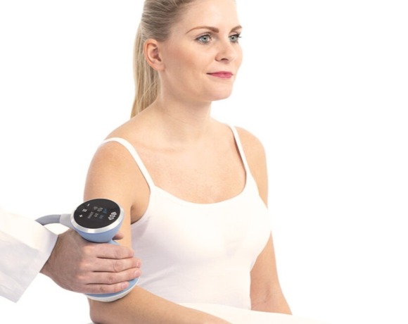 Kobieta w białym topie otrzymująca zabieg masażu ramienia w jasnym, profesjonalnym spa