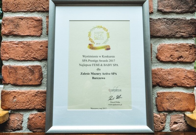 Certyfikat SPA Prestige 2017 dla Zalesie Mazury Active SPA w srebrnej ramie na tle ceglanej ściany