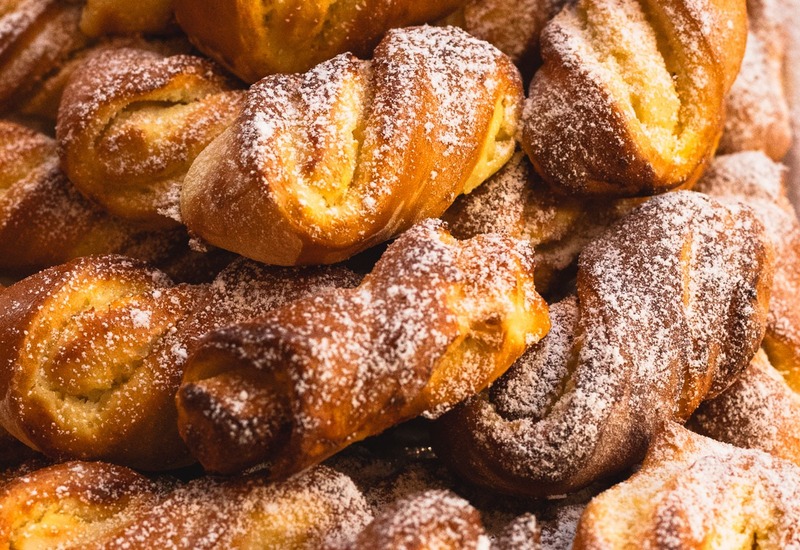 Ciepłe, świeżo wypieczone słodkie warkoczyki posypane cukrem pudrem, idealne na hotelowe śniadanie