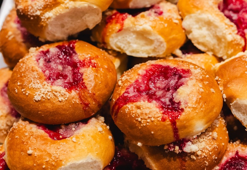 Bułeczki śniadaniowe z malinowym dżemem i kruszonką na białej tacy przy bufecie hotelowym