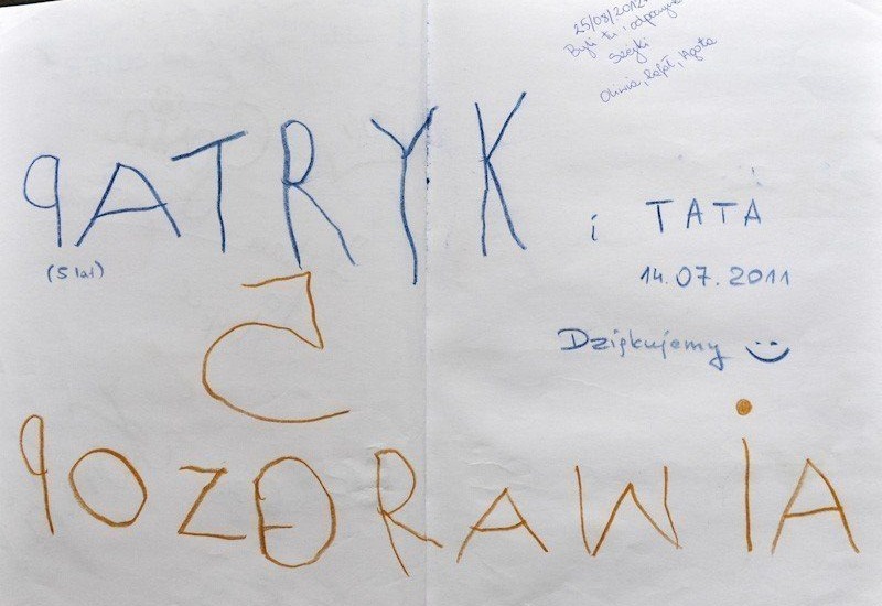 Strona księgi gości z kolorowymi wpisami kredką i długopisem: 'Patryk i tata' i 'Pozdrowienia', data 14.07.2011, dopisek 'Dziękujemy' z uśmiechem.