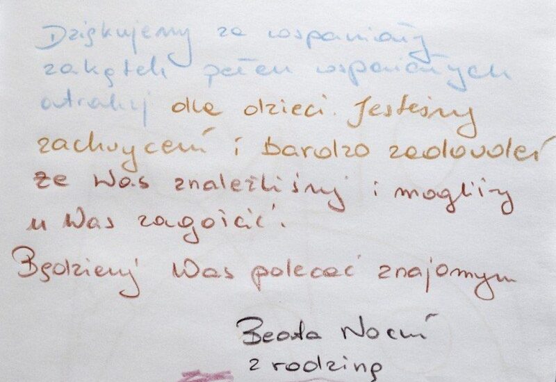 Wpis w księdze gości po polsku, kolorowy odręczny tekst dziękujący za pobyt rodzinny, polecający hotel, podpis na dole