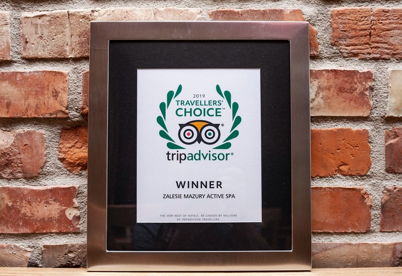 Certyfikat TripAdvisor Travellers' Choice 2019 — nagroda dla Zalesie Mazury Active Spa w metalowej ramce na odsłoniętej ceglanej ścianie